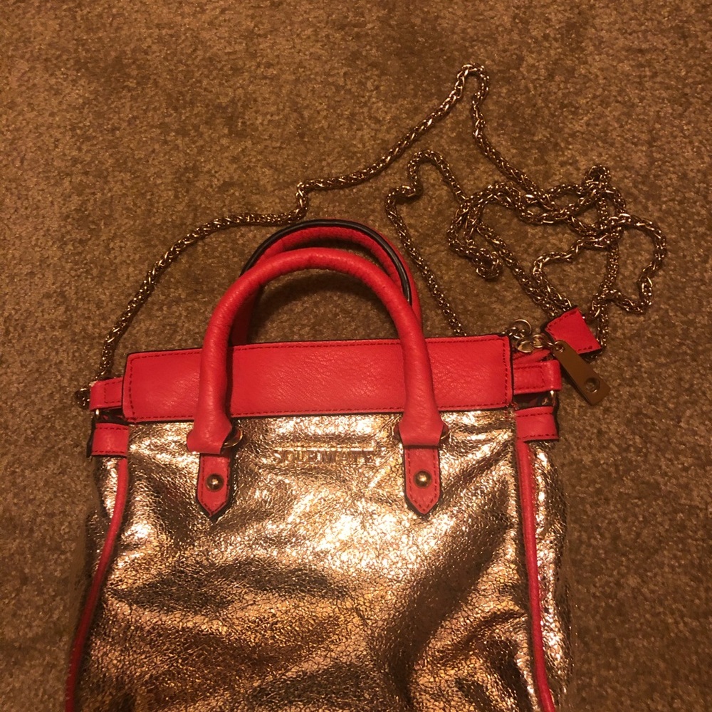 Small Cross Body or shoulder bag. Gold with pink outline. New,never used.